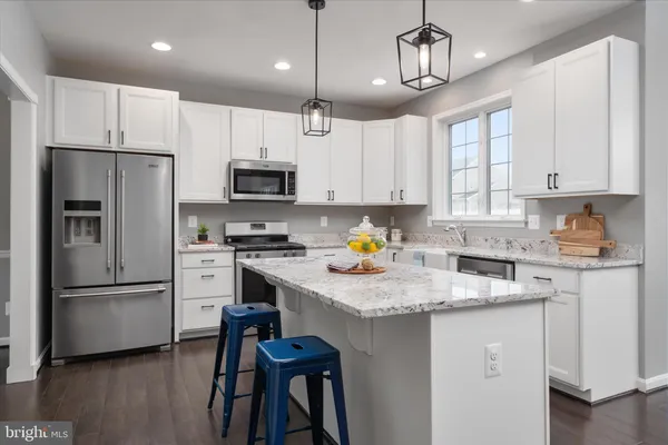 a kitchen with kitchen island granite countertop stainless steel appliances cabinets a sink and a counter top space