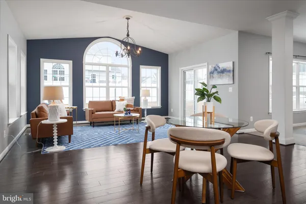 a living room with furniture a large window and wooden floor
