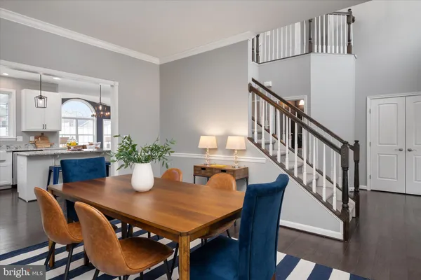 a view of a dining room with furniture a rug and wooden floor