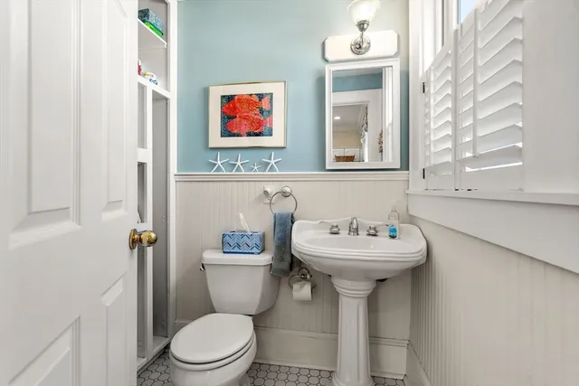 a bathroom with a sink mirror toilet and a window