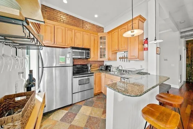 a kitchen with stainless steel appliances granite countertop a sink stove and refrigerator