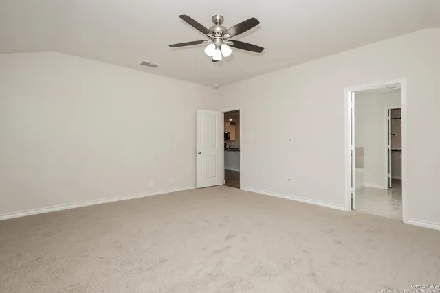 an empty room with closet and a ceiling fan