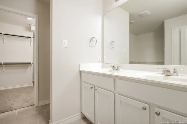 a bathroom with a double vanity sink and mirror