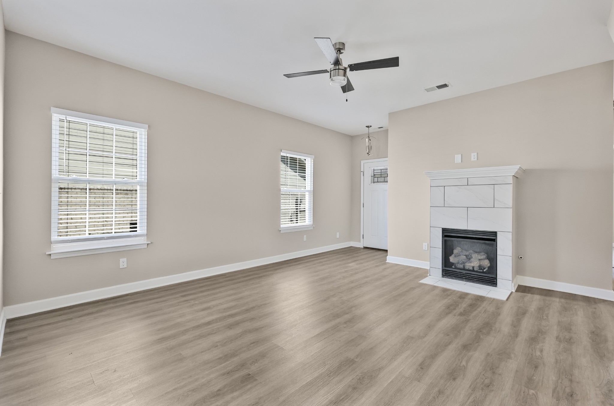 871 Blessing Way Gallatin, TN 37066 - Photo 4 of 25 an empty room with windows fireplace and wooden floor