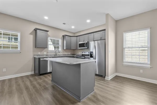 a kitchen with stainless steel appliances granite countertop a refrigerator sink and cabinets
