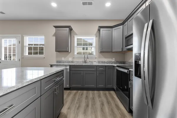 a kitchen with stainless steel appliances granite countertop a refrigerator and a sink