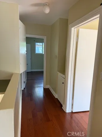a view of a hallway with wooden floor and closet