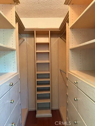 a view of walk in closet with empty racks