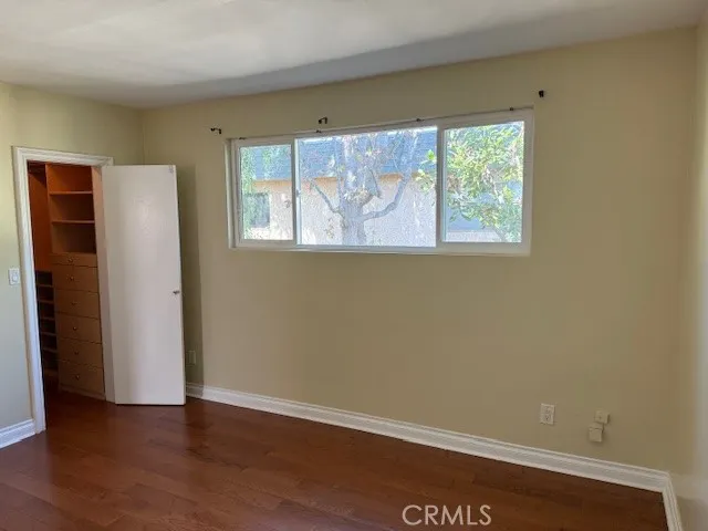 an empty room with wooden floor and a window