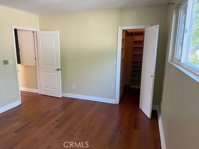 an empty room with wooden floor and closet