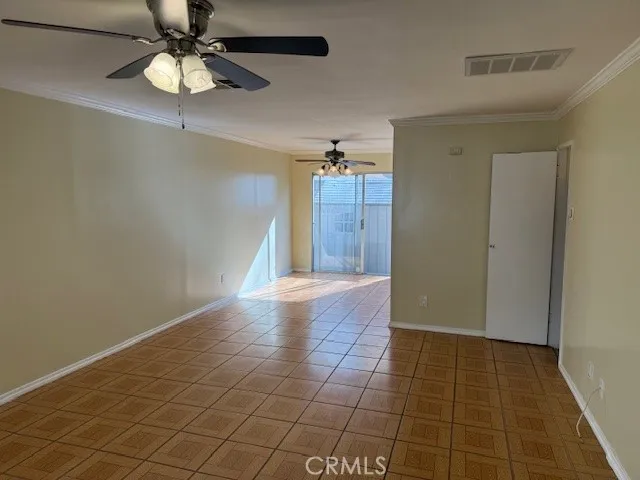 wooden floor in an empty room with a chandelier fan