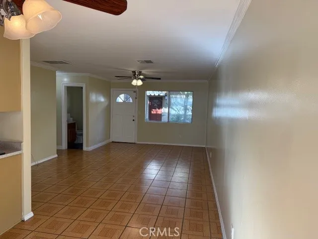 a view of an empty room with a chandelier fan