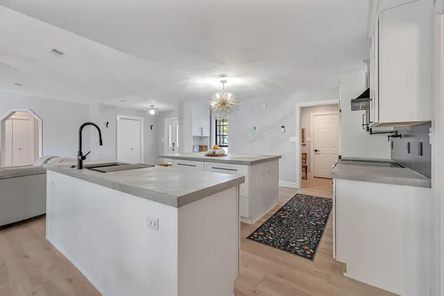 a large kitchen with stainless steel appliances granite countertop a stove and a sink
