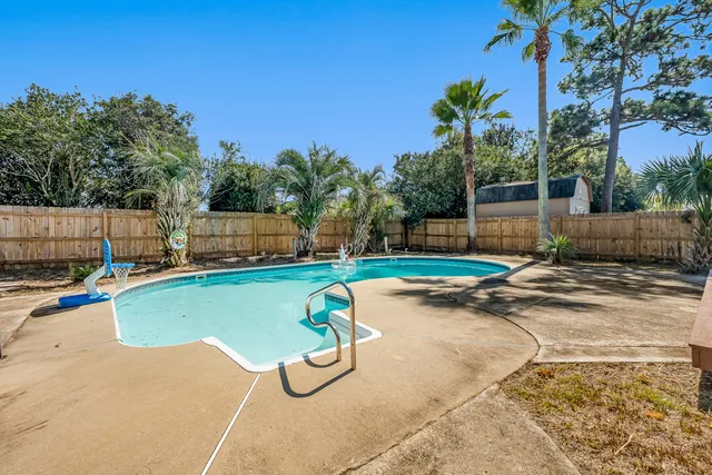 a view of a backyard with basketball court