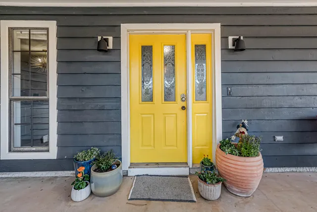 an empty room with wooden floor closet and windows