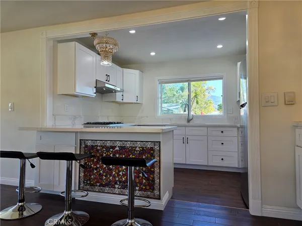 a kitchen with a fireplace and wooden floors