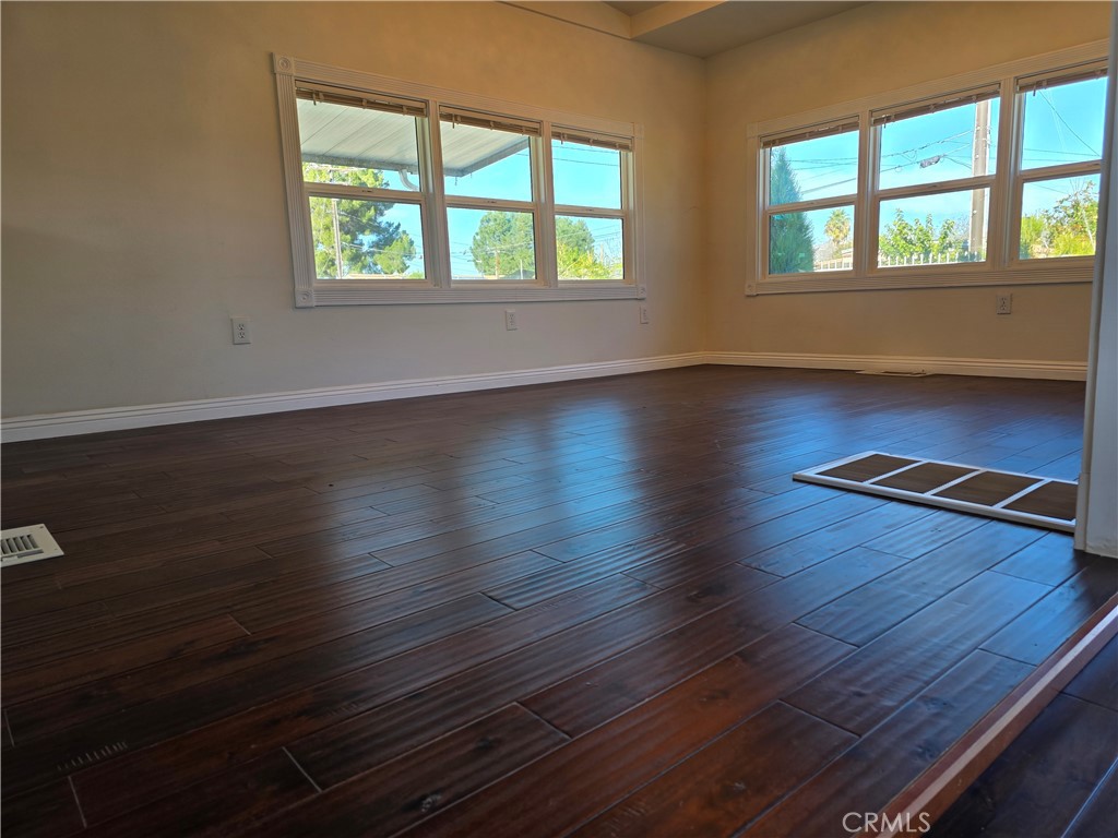 45371 Cardiff Street Hemet, CA 92544 - Photo 8 of 14 an empty room with wooden floor and windows