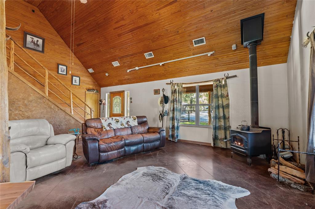 262 North Cheyenne Springtown, TX 76082 - Photo 4 of 35 Living room with high vaulted ceiling, a wood stove, and wooden ceiling