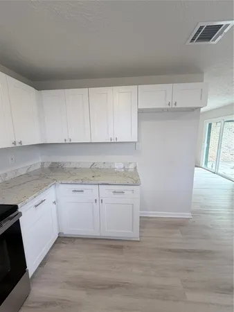 a kitchen with granite countertop white cabinets and white appliances