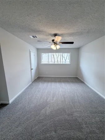 an empty room with a window and a ceiling fan