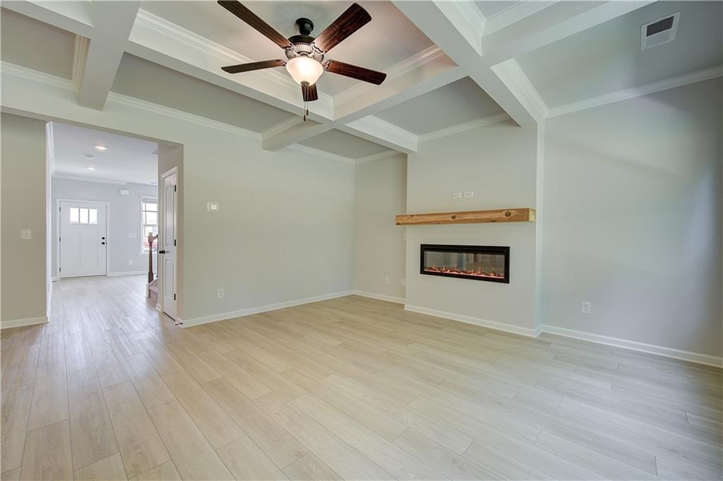 119 St Anne's Place Covington, GA 30016 - Photo 12 of 30 an empty room with wooden floor and a ceiling fan