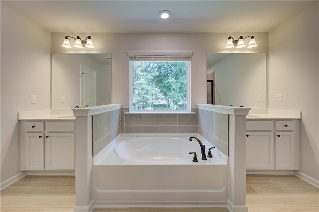 119 St Anne's Place Covington, GA 30016 - Photo 25 of 30 a bathroom with a bathtub a window and mirror