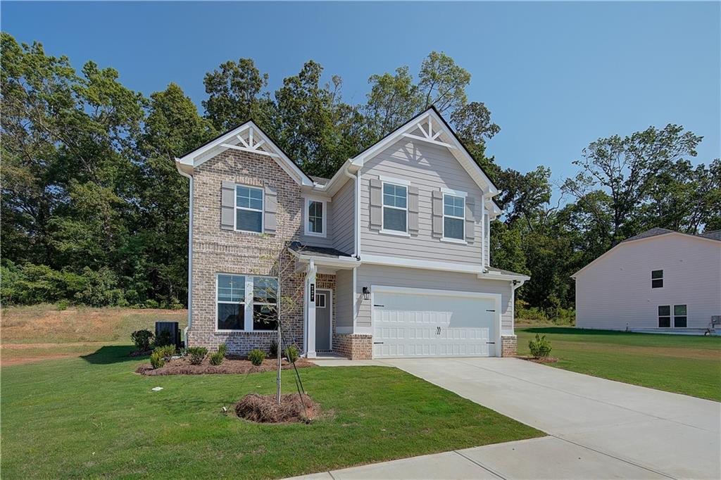 119 St Anne's Place Covington, GA 30016 - Photo 3 of 30 a front view of a house with garden and trees