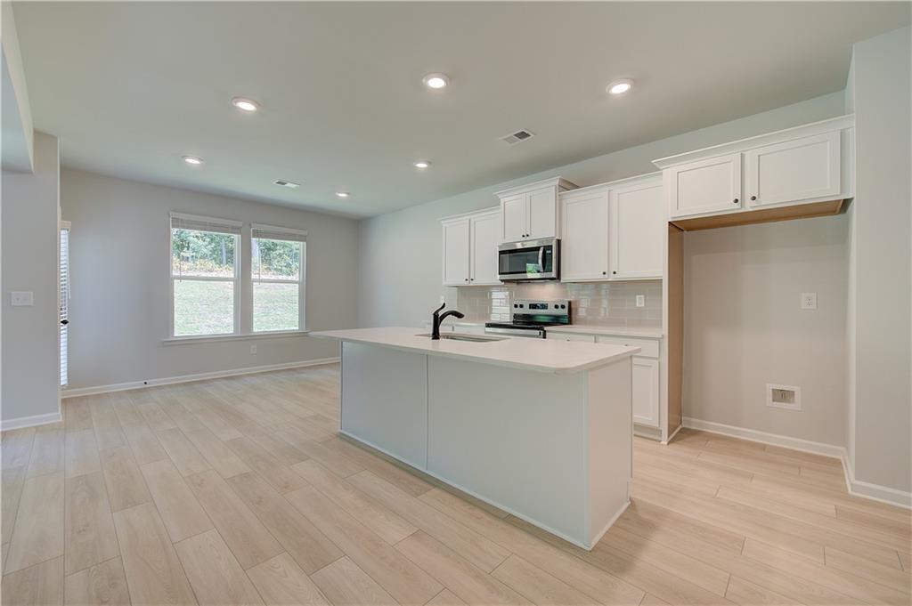 119 St Anne's Place Covington, GA 30016 - Photo 7 of 30 a view of kitchen with center island and stainless steel appliances