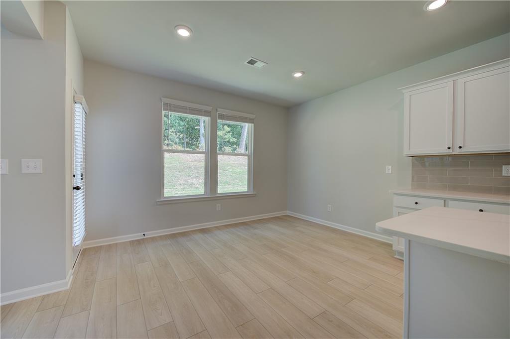 119 St Anne's Place Covington, GA 30016 - Photo 10 of 30 an empty room with wooden floor and windows