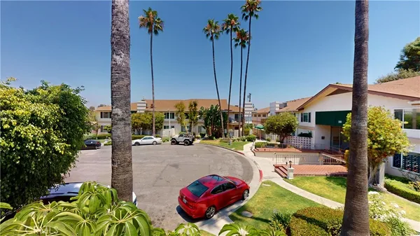 a view of a patio with couches table and chairs under an umbrella with a fire pit