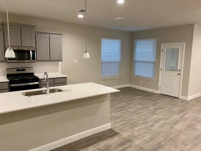 a kitchen with stainless steel appliances granite countertop a sink stove and refrigerator