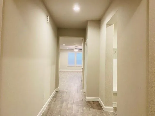 a view of a hallway with wooden floor