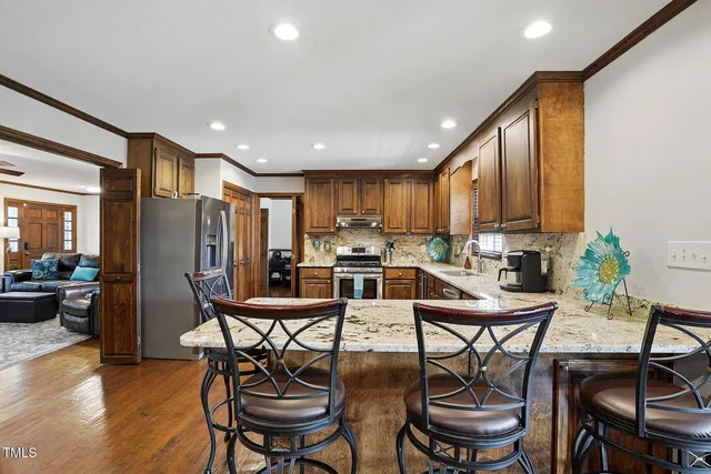 a kitchen with a dining table chairs and refrigerator