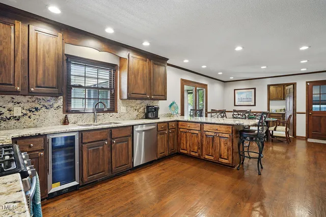 a large kitchen with stainless steel appliances granite countertop wooden cabinets a sink and dishwasher a oven with wooden floors