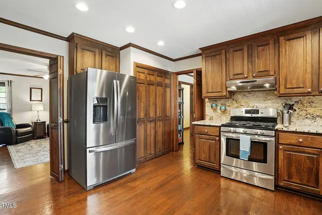 a kitchen with stainless steel appliances granite countertop a refrigerator stove and sink
