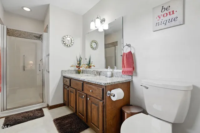 a bathroom with a granite countertop toilet sink and mirror