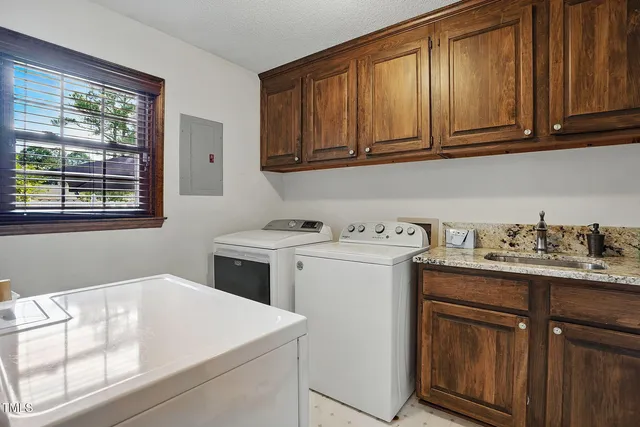 a utility room with sink dryer and washer