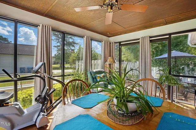 a vase of flowers sitting on a table with window