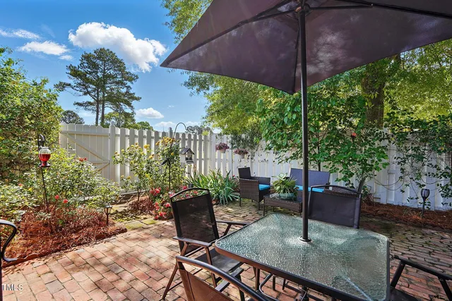 a view of a patio with table and chairs under an umbrella