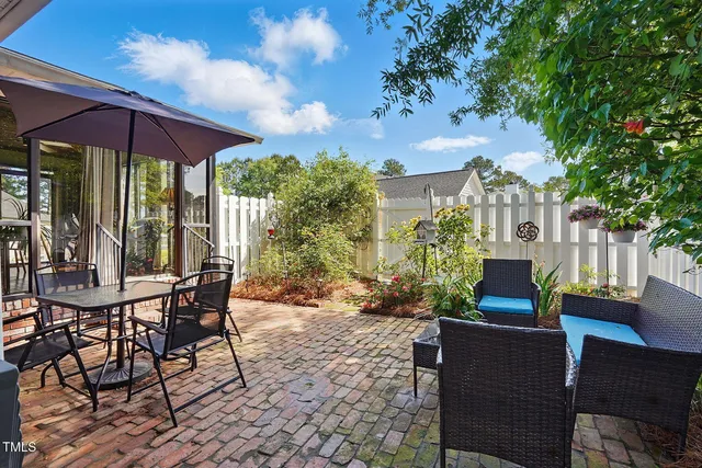 a view of a patio with table and chairs under an umbrella
