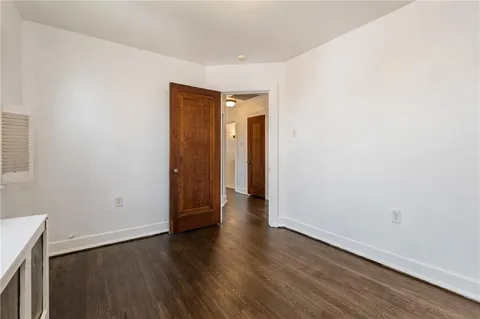 an empty room with wooden floor and closet