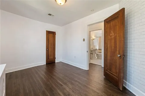 an empty room with wooden floor and a bathroom