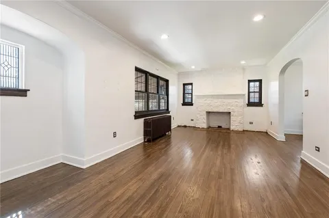 an empty room with wooden floor and a fireplace