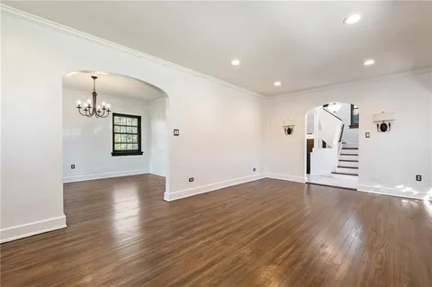 an empty room with wooden floor and mirror