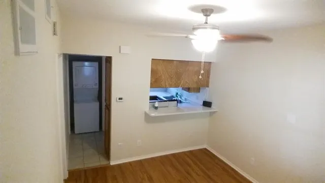 a view of a hallway with a refrigerator and a chandelier