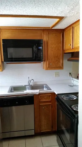 a kitchen with stainless steel appliances a stove a sink and a microwave