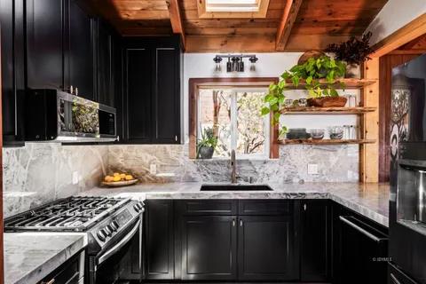 a kitchen with stainless steel appliances granite countertop a sink stove and cabinets
