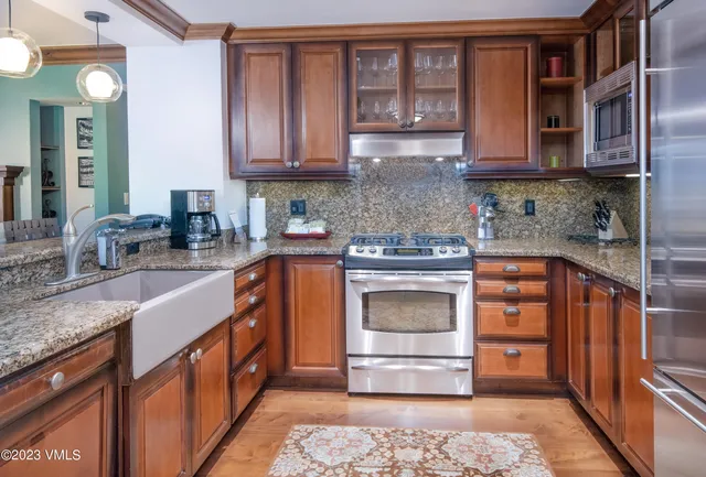 a kitchen with stainless steel appliances granite countertop a stove and cabinets