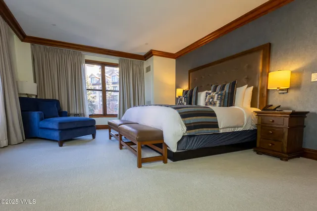 a bedroom with a bed and a couch next to a window