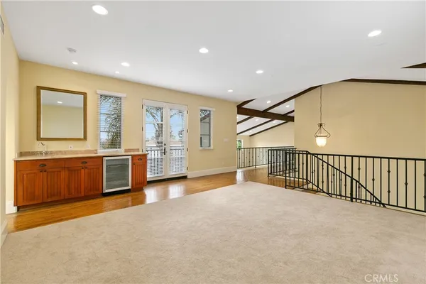 a view of an empty room with a window and kitchen view